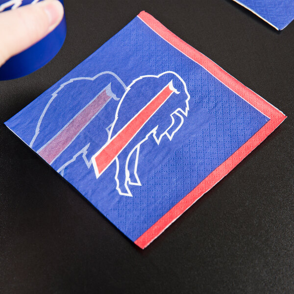 A blue Creative Converting beverage napkin with a red and white buffalo design.