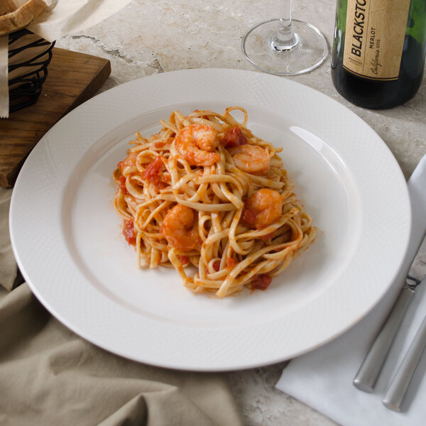 A Villeroy & Boch white porcelain plate with pasta, shrimp, and wine.
