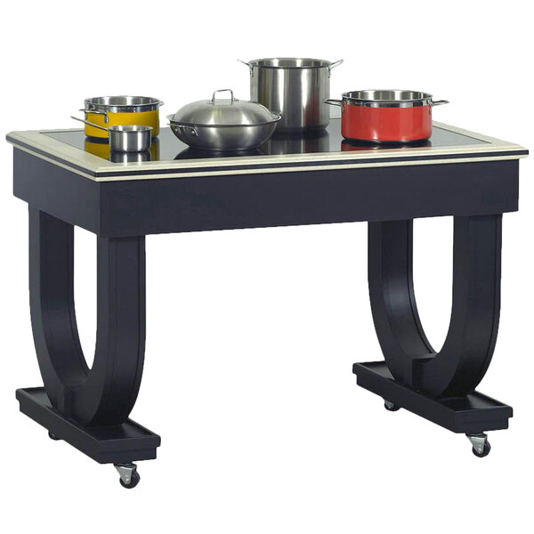 A black Bon Chef wood table with 2 induction warmers and pots on it.