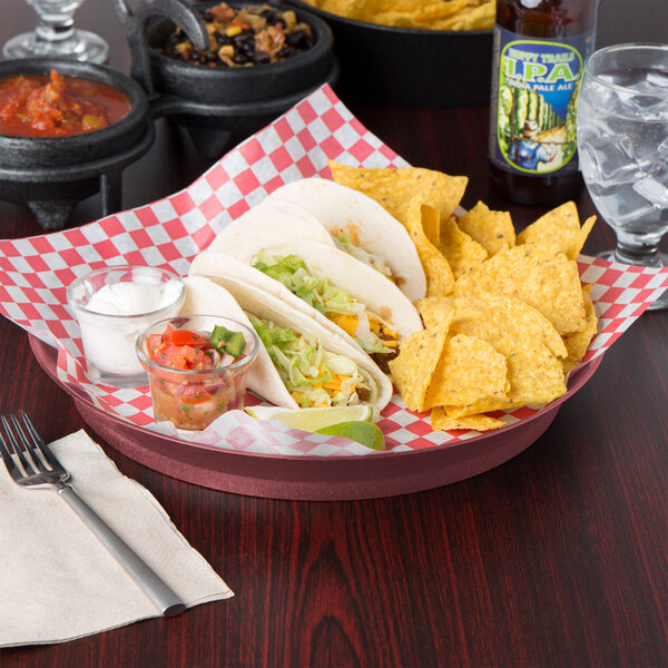 A table with a plate of tacos, chips, and a bowl of salsa served on HS Inc. raspberry deli servers with short bases.