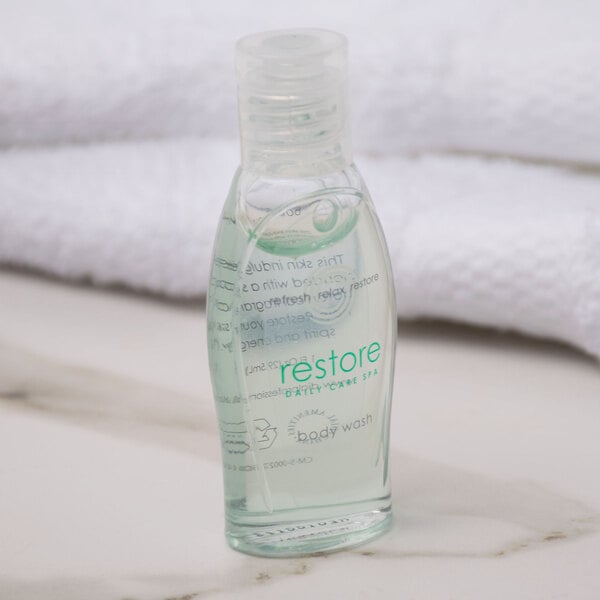 A small plastic bottle of Dial Restore body wash with clear liquid inside.