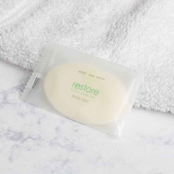 A white package of Dial Restore Basics Body Bar soap on a white towel.