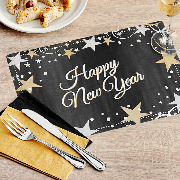 A Hoffmaster New Year's placemat on a table with a plate of food and a glass of wine.