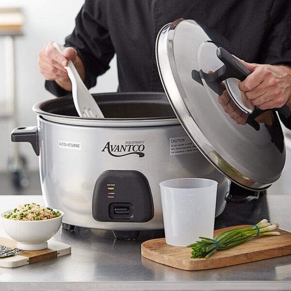 A man using an Avantco commercial rice cooker to cook rice.