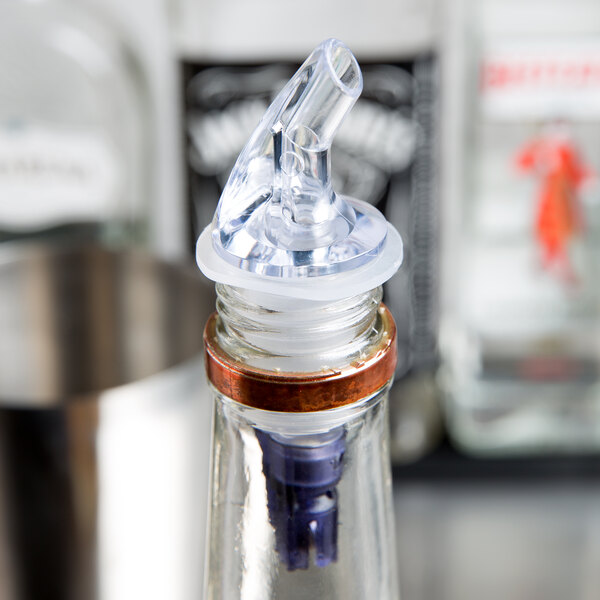 A close-up of a clear Thunder Group liquor pourer with a purple tail.