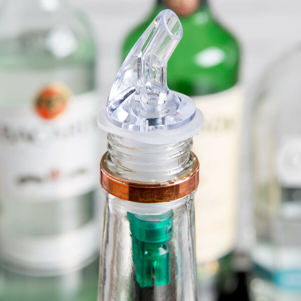 A close-up of a clear Thunder Group liquor pourer with a green tail.