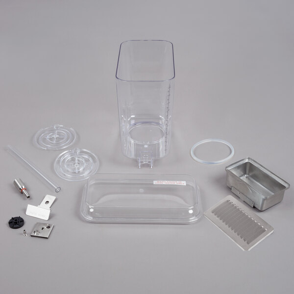 A Crathco refrigerated beverage dispenser bowl and drip tray assembly kit on a table with other clear plastic containers.