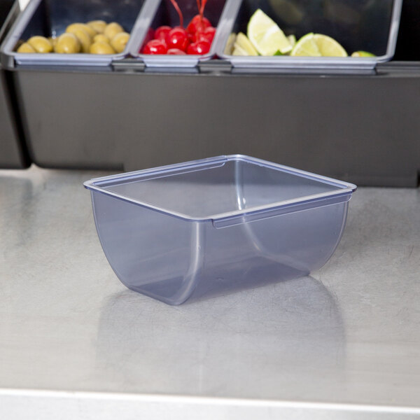 A clear plastic San Jamar tray with a lid on a counter.