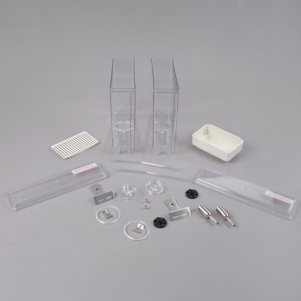 A group of white plastic parts including a rectangular bowl with black lines and a rectangular drip tray.