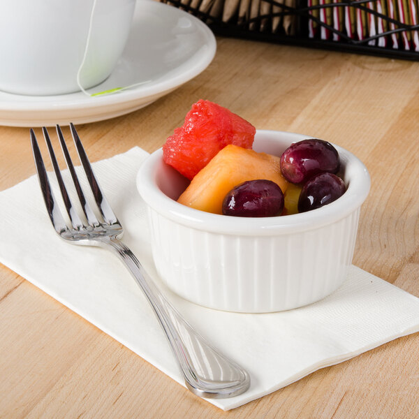 A close-up of a Tuxton fluted white ramekin with fruit in it.