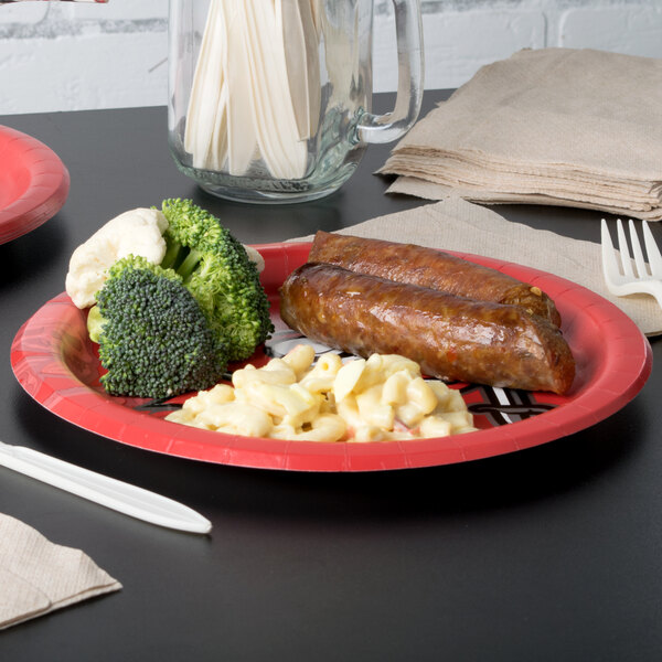 A Tampa Bay Buccaneers paper dinner plate with sausage and broccoli on it.