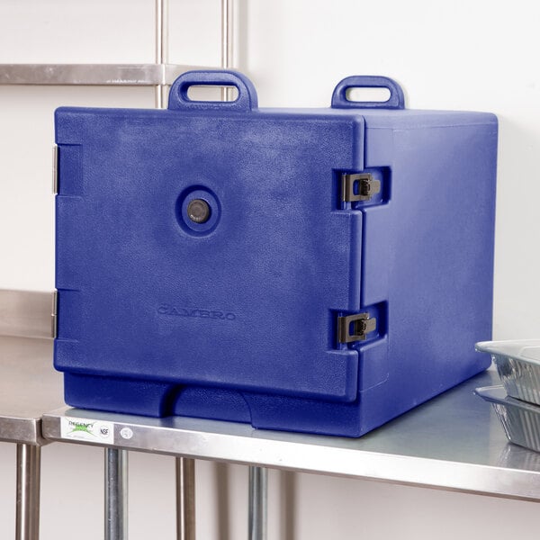 A navy blue Cambro insulated tray and sheet pan carrier on a metal shelf.