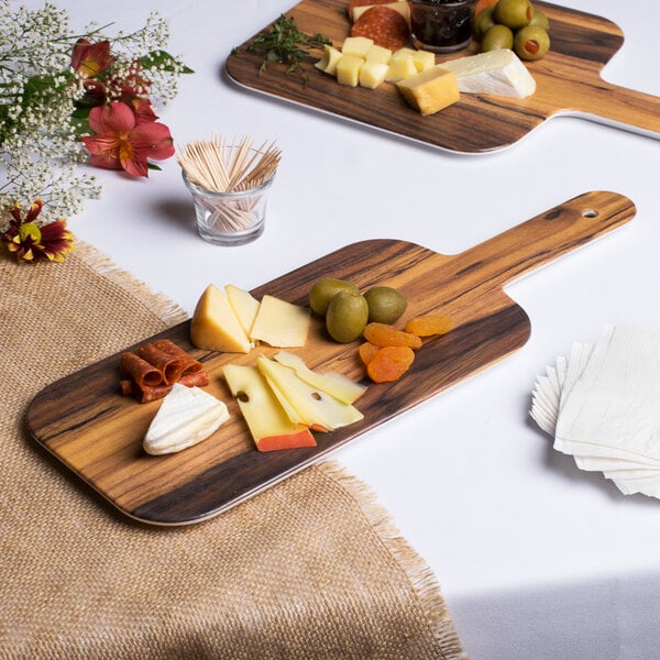 An American Metalcraft rectangular melamine serving peel with cheese, olives, and grapes on a wooden board.