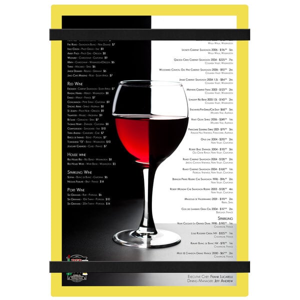A Menu Solutions yellow acrylic menu board with a glass of wine on a table.