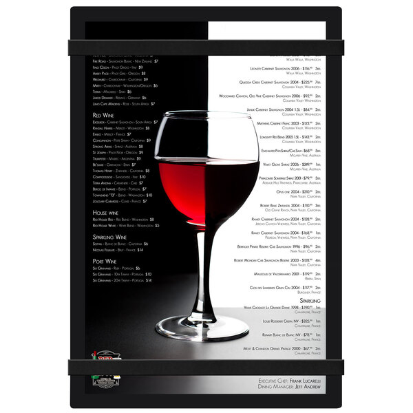 A wine glass with red liquid on a Menu Solutions black acrylic menu board with rubber band straps.