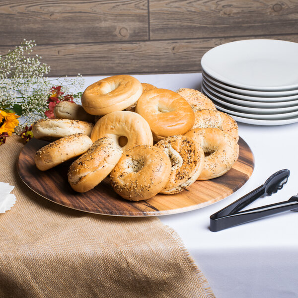 An American Metalcraft faux acacia melamine serving board with bagels on a table.