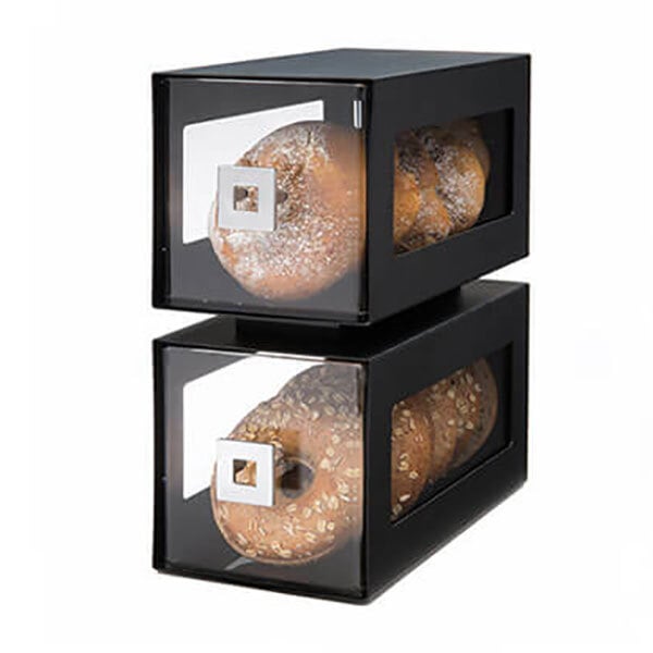 A black steel bakery display column with two black boxes of donuts inside.