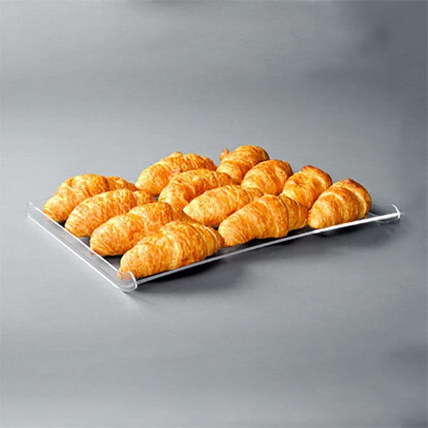 A clear Rosseto bakery display tray with croissants on it.