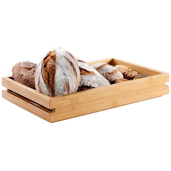 A Rosseto bamboo tray with bread in it on a table.