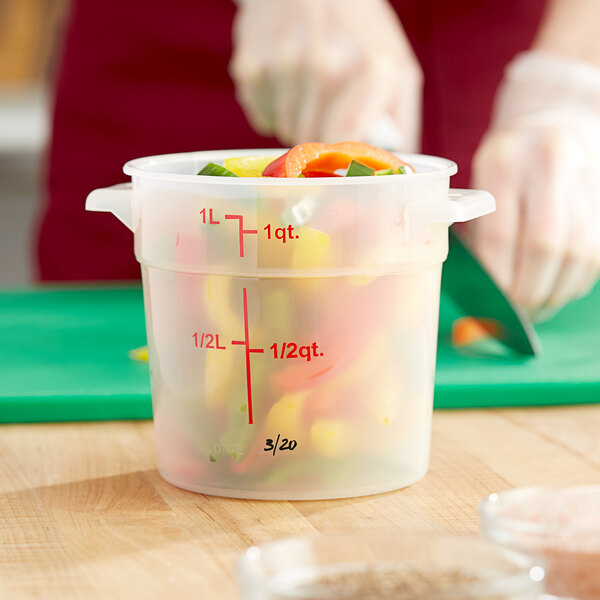 A translucent round plastic container filled with vegetables.