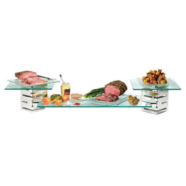 A Rosseto tempered glass shelf on a stainless steel riser with food on it.