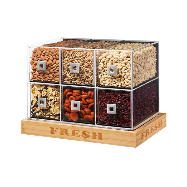 A wooden bakery display case with a square white base holding a variety of nuts and dried fruits.