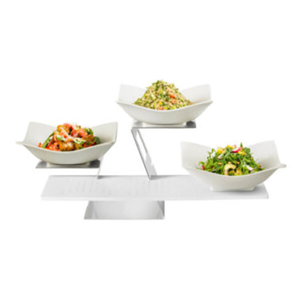 A Rosseto display riser with three bowls of food on a white surface.
