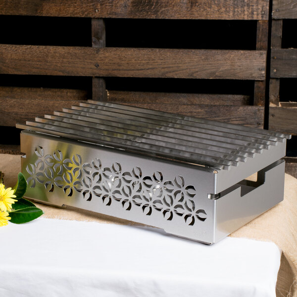 A stainless steel Rosseto chafer alternative with a grill top on a table.