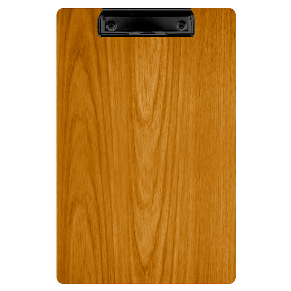 A Menu Solutions wood clipboard with a black clip on a wood surface.
