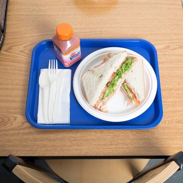 A blue plastic Choice fast food tray with a sandwich and a bottle of juice on it.