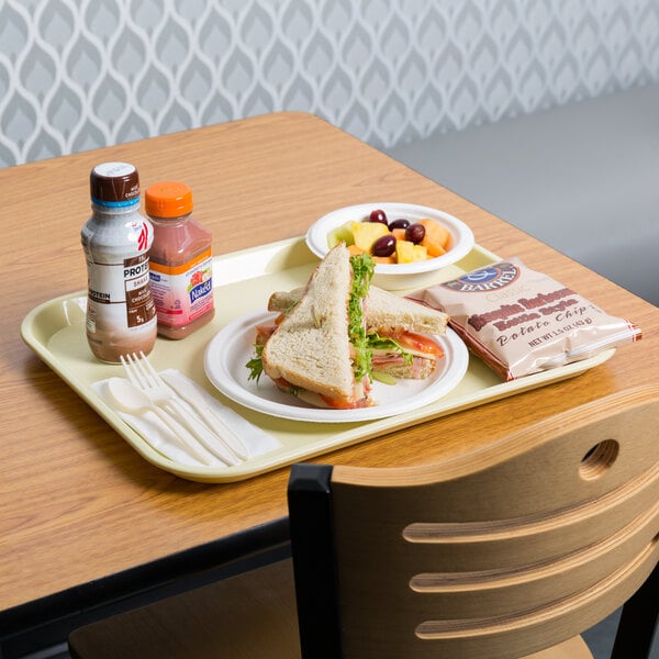 A beige plastic fast food tray with a sandwich and drink on it.
