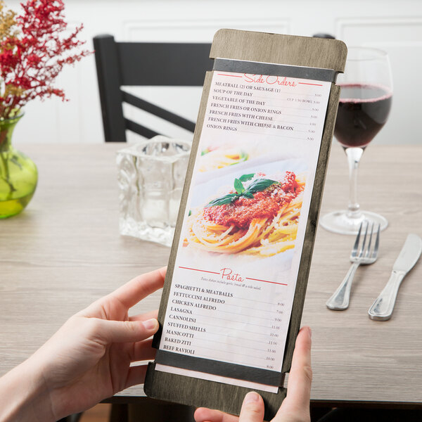 A person holding a Menu Solutions wood menu board with rubber band straps.