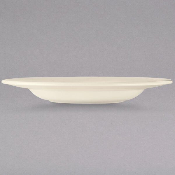 A Libbey cream white china pasta bowl with a black rim.