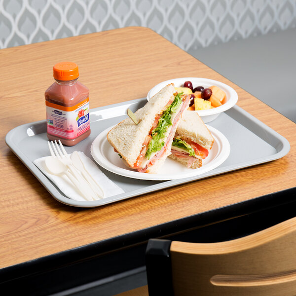 A Choice gray plastic fast food tray with a sandwich and fruit on it.