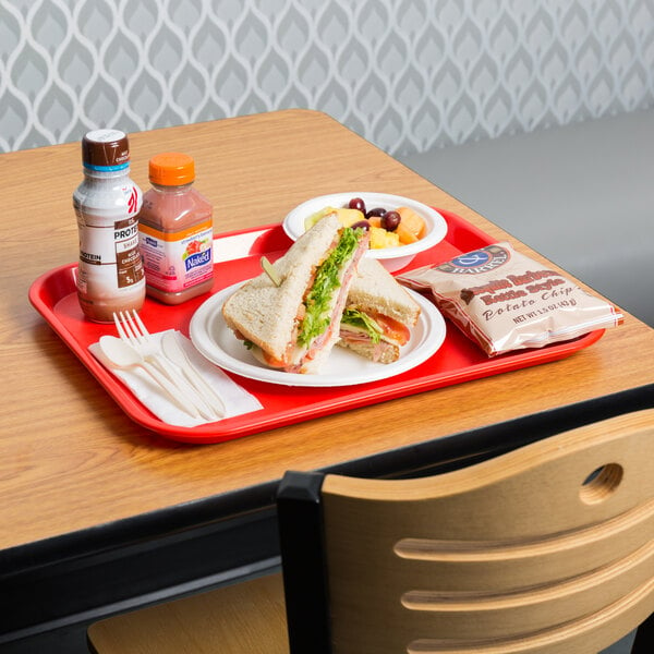 A red Choice plastic fast food tray with a sandwich and other food on it.