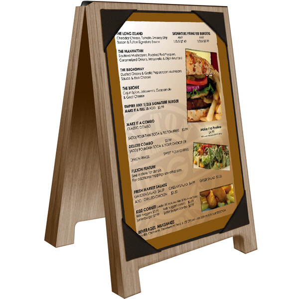 A Menu Solutions weathered walnut wood sandwich menu board with picture corners on a table with a menu and a burger.