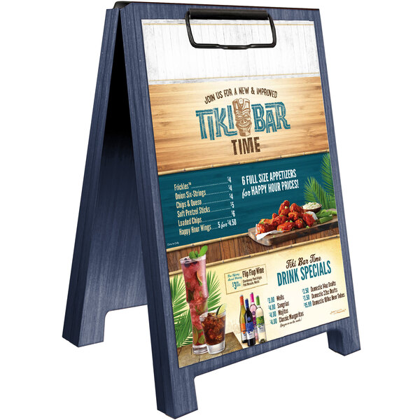 A Menu Solutions wooden denim sandwich menu board tent on a table with a menu clip.