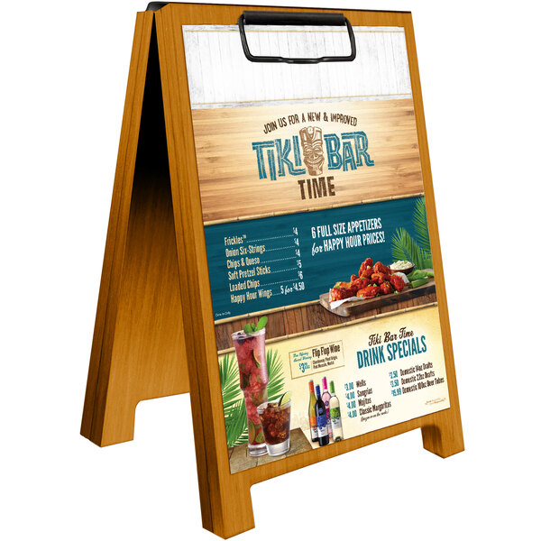 A Menu Solutions country oak wood menu board tent with a clip on a table.