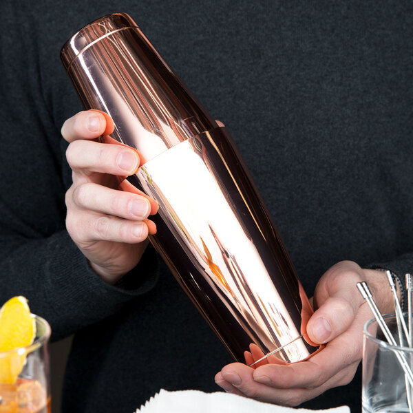 A person holding a Barfly copper Boston cocktail shaker.