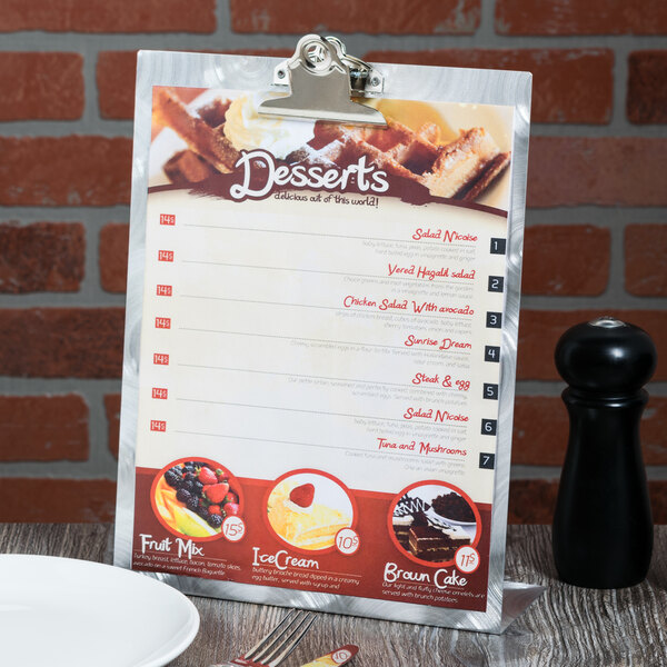 A Menu Solutions Alumitique aluminum table tent on a table with a picture of desserts on it.