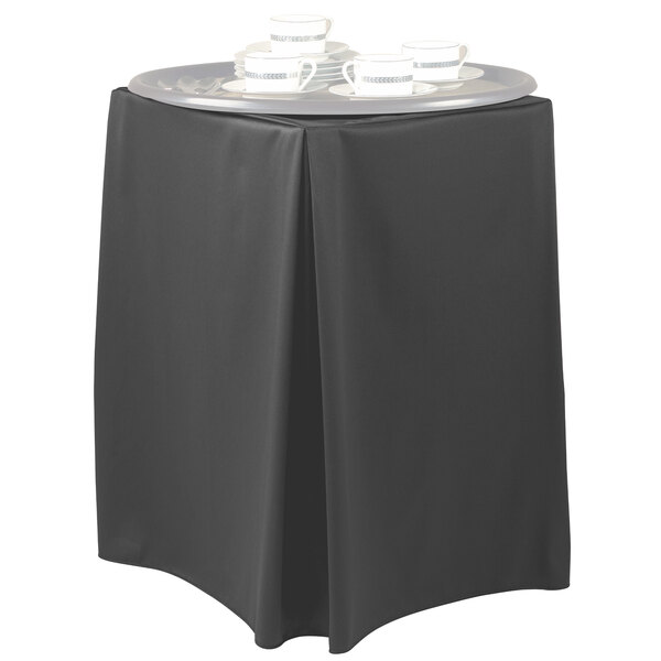 A black Snap Drape tray stand cover on a table with a tray of teacups.