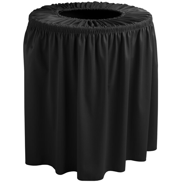 A black Snap Drape shirred pleat round trash can cover on a table with a black tablecloth.