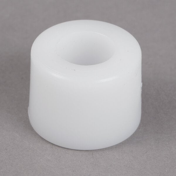 A white plastic Garde guide rod bushing on a gray surface.