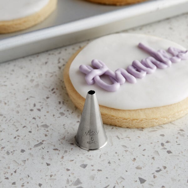 A cookie with frosting piped on it using an Ateco plain piping tip.