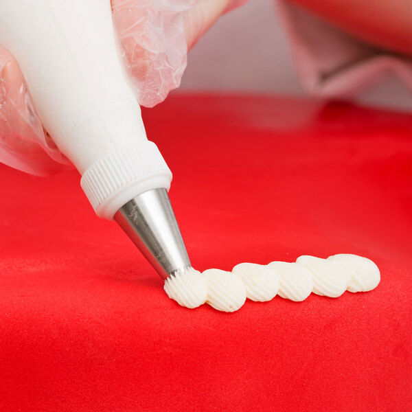 A person using an Ateco drop flower piping tip on a pastry bag.