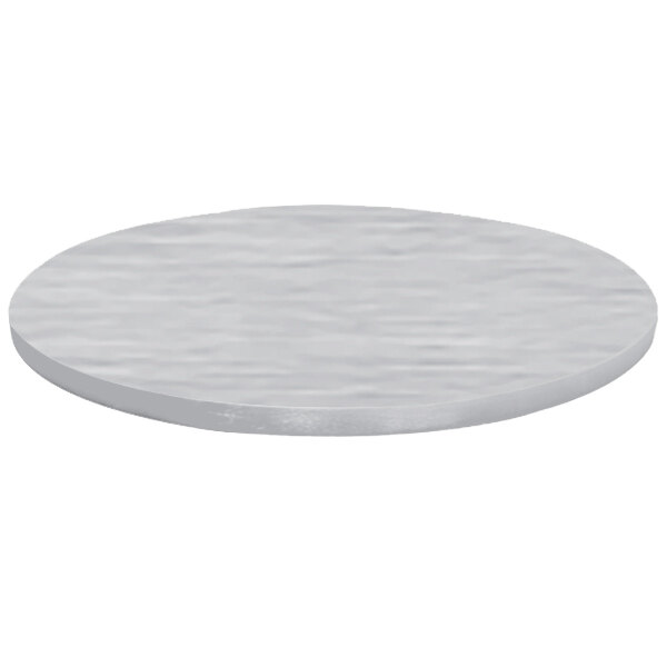 A close-up of a Tablecraft brushed aluminum round table cover on a table with a white surface.