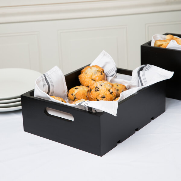 A black Tablecraft wood crate with muffins on a table.