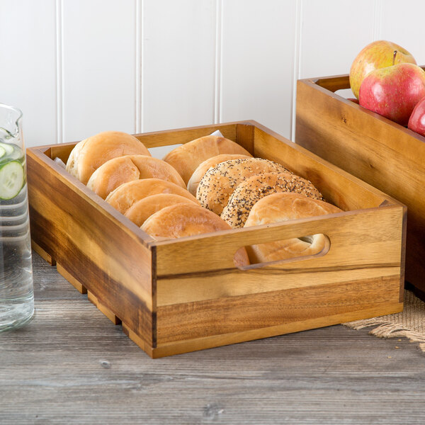 A Tablecraft acacia wood gastronorm display crate filled with bread and apples.