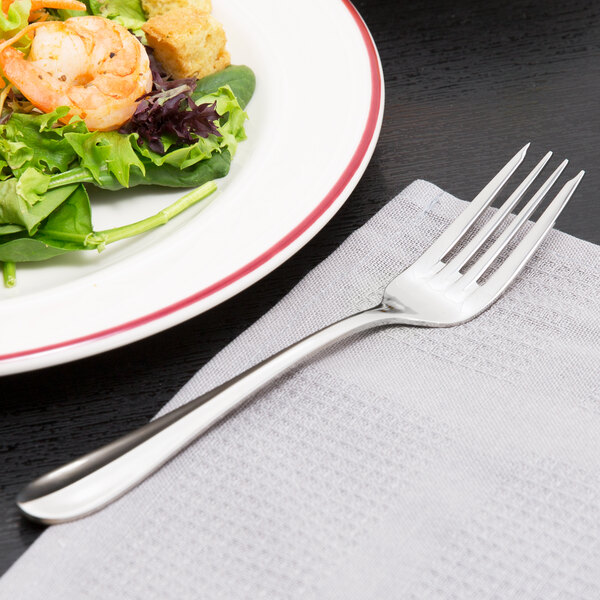 A Walco Lancer stainless steel salad fork on a plate of salad.
