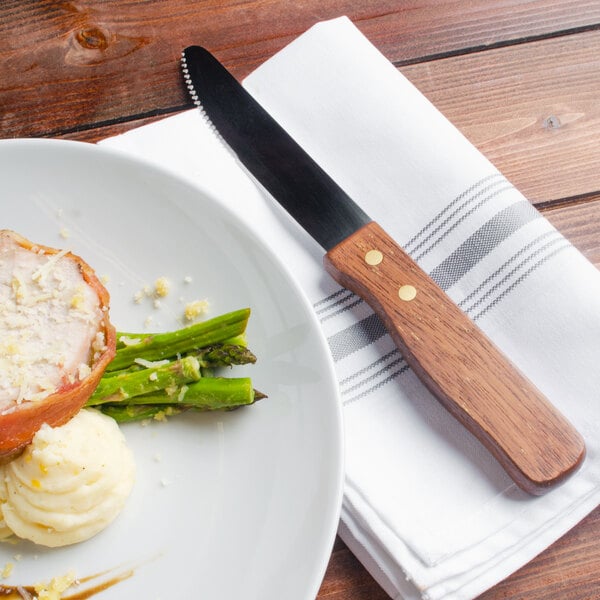A plate of food with a Walco Utica II steak knife.